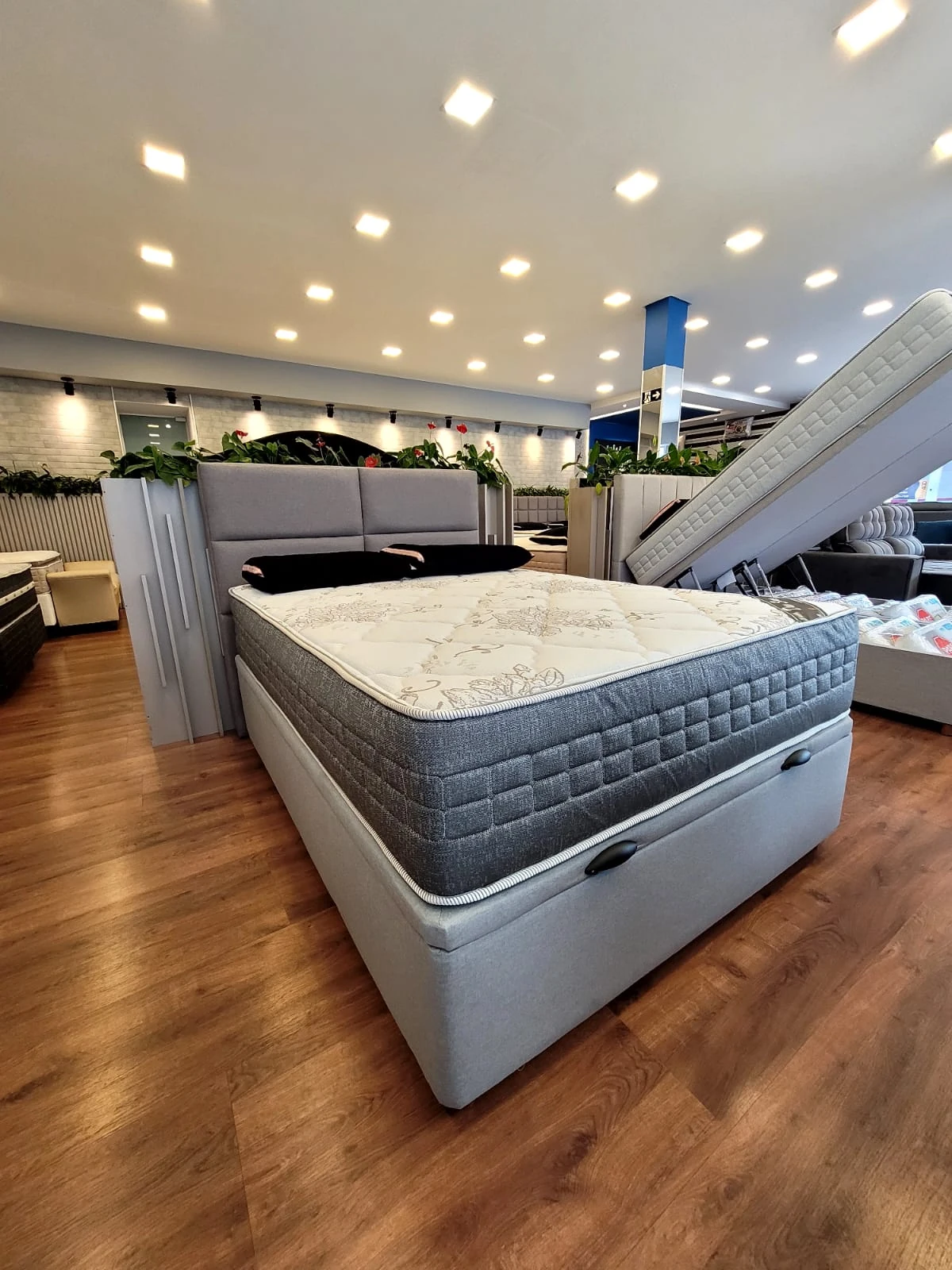 Cama e box cinza fotografados no showroom da King