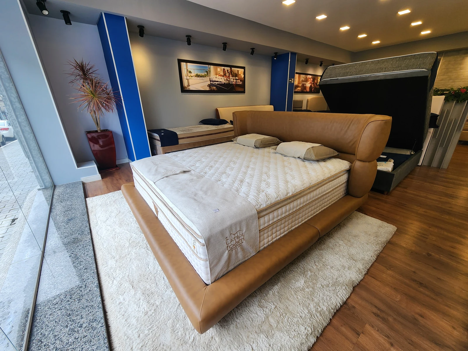 Cama com cabeceira em tom caramelo, fotografada na loja King